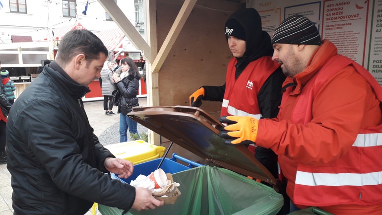 Tomáš a Angel (sprava) usmerňujú ľudí pri triedení odpadkov