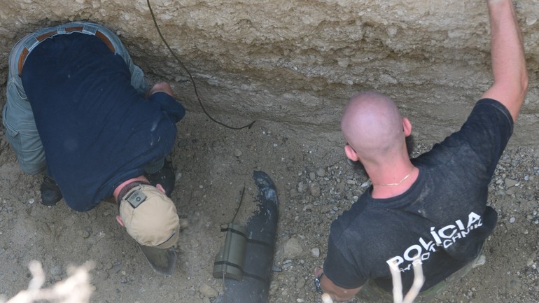 policajný pyrotechnik dohliada na zahrabanie leteckej bomby